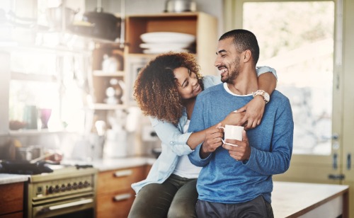 Two people smiling standing in kitchen